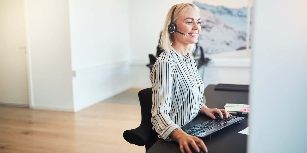 smiling-businesswoman-working-at-her-desk-and-wear-2021-08-27-11-10-43-utc-min.jpg